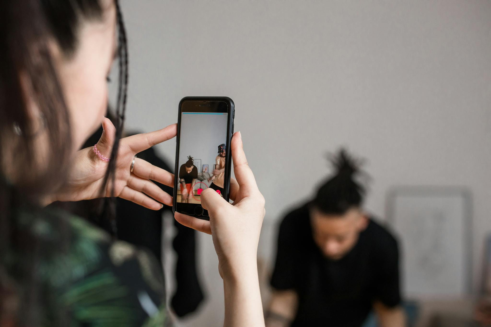 Close-up of a person recording a video with a smartphone indoors, focusing on creative content creation.